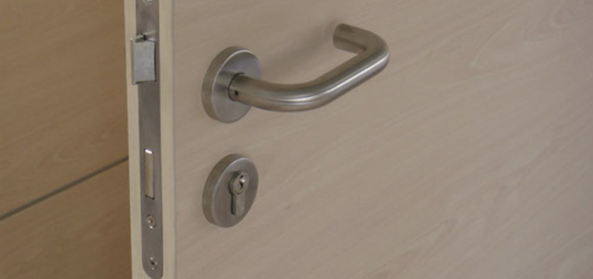 Foto Detalle de picarporte cromado en puerta de madera para divisorias de oficina